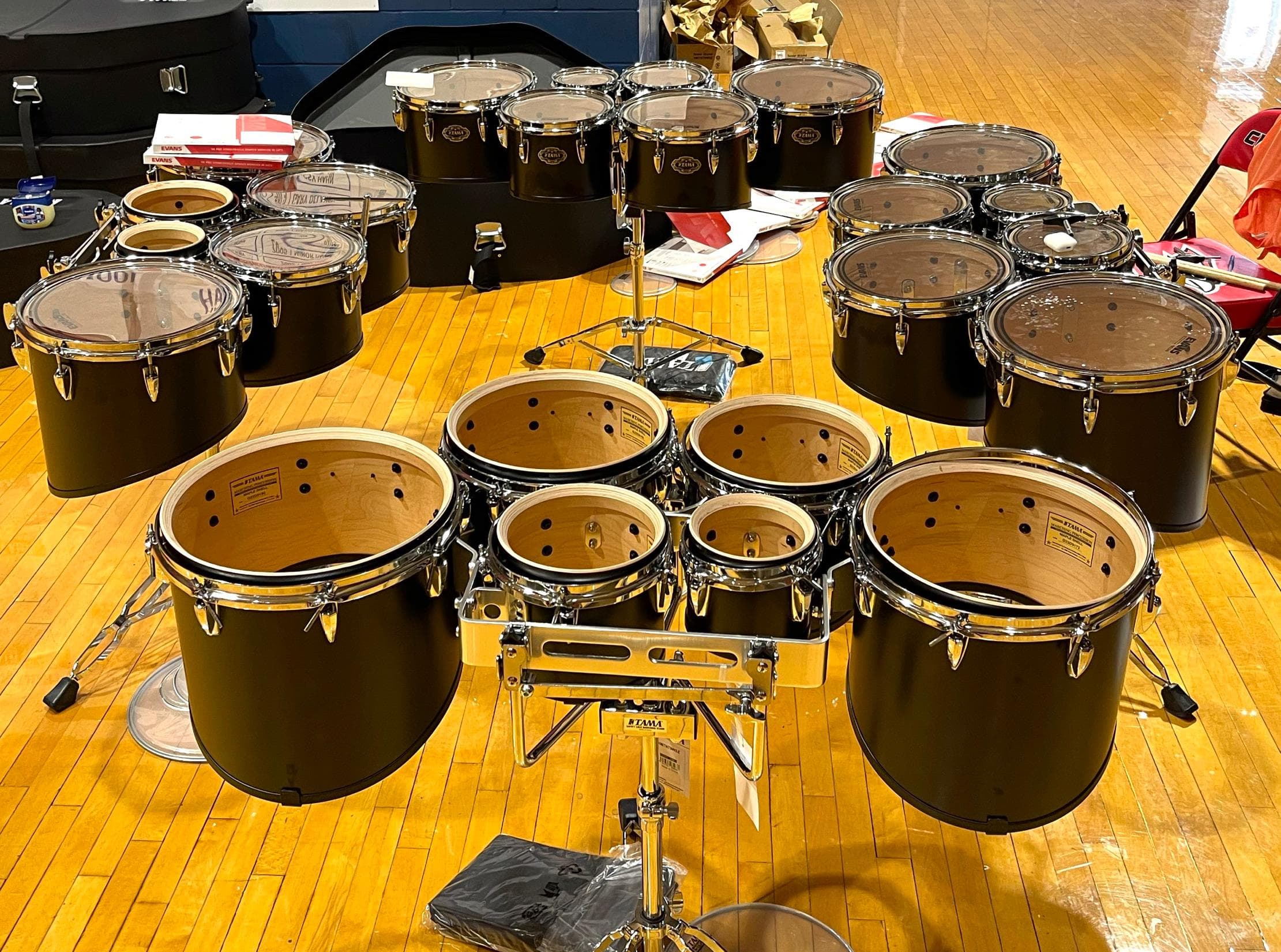 Marching percussion drums arranged in a rehearsal space